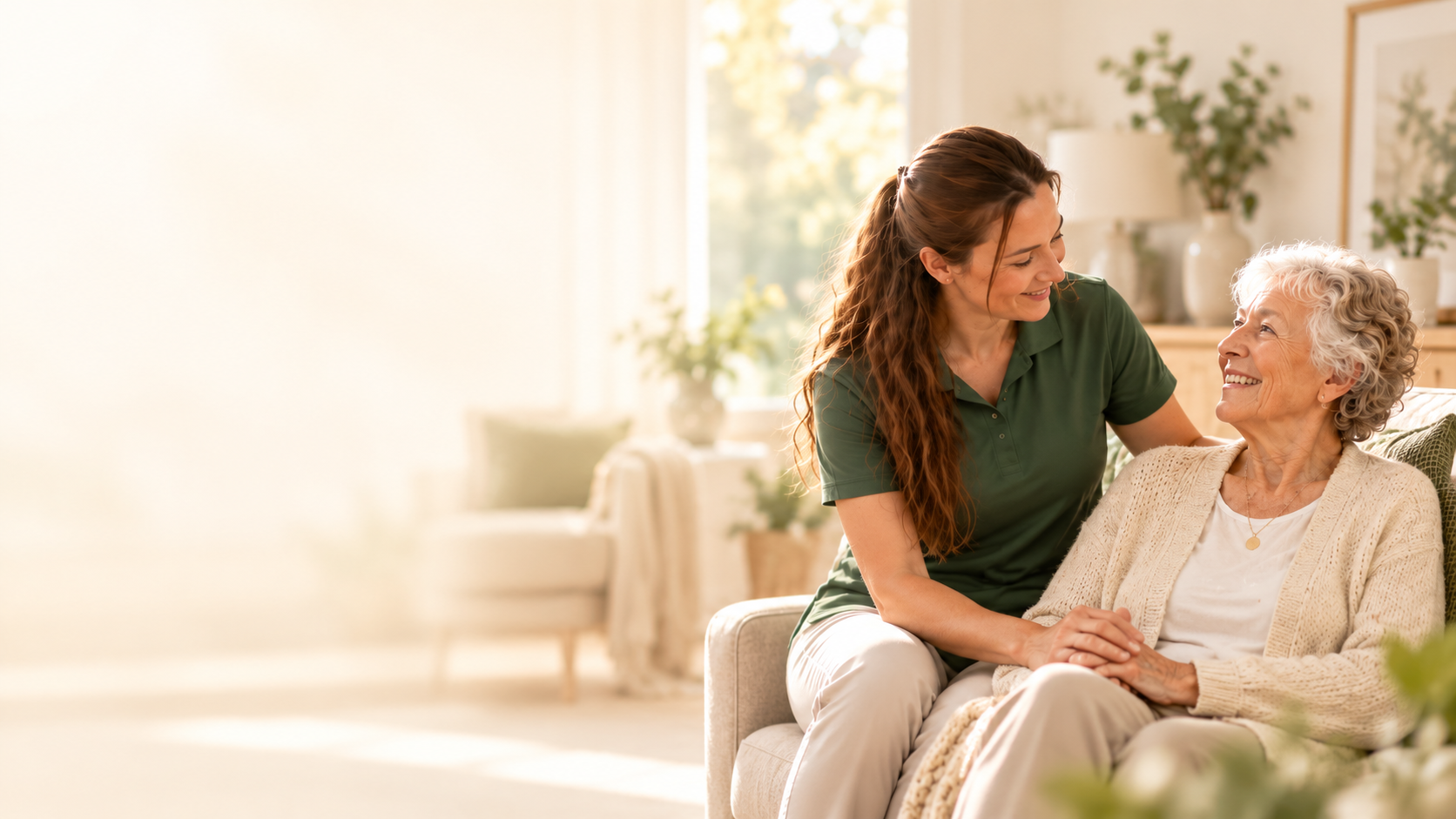Mitarbeiterin von Daily Plus im Gespräch mit einer älteren Dame auf dem Sofa